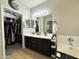 Well-lit bathroom featuring a double sink vanity, a large mirror, and a walk in closet at 9024 W Alda Way, Peoria, AZ 85382