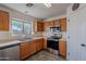 Bright kitchen with wood cabinets, double sink, and stainless steel appliances at 909 W Elm Ave, Coolidge, AZ 85128