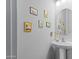 Small powder room with pedestal sink and decorative wall art at 1040 N 113Th Pl, Mesa, AZ 85207
