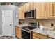 Kitchen boasts granite countertops, stainless steel appliances, and wood cabinets at 1040 N 113Th Pl, Mesa, AZ 85207