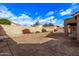 Sunny backyard with grassy area and block wall at 13450 W Maui Ln, Surprise, AZ 85379