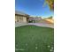 Artificial turf backyard with a patio and block wall at 13622 W Peck Ct, Litchfield Park, AZ 85340