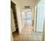 Hallway with tile flooring and access to multiple rooms, showcasing the home's layout at 13622 W Peck Ct, Litchfield Park, AZ 85340