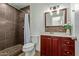 Updated bathroom with dark tile shower and wood vanity at 1510 E Edgewood Ave, Mesa, AZ 85204