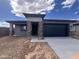 Charming single-story home with a dark blue garage door and complementary stone pillar accents at 20596 N 226Th Dr, Surprise, AZ 85387