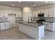 Modern kitchen with white cabinetry, stainless steel appliances, a gray granite island, and tile flooring at 20596 N 226Th Dr, Surprise, AZ 85387