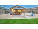 Backyard view with a covered patio, stone pavers, seating, gravel and artificial grass at 23820 W Mobile Ln, Buckeye, AZ 85326