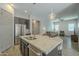 Kitchen island with granite countertop, stainless steel sink and open layout to living room at 2931 E Citrus Way, Chandler, AZ 85286