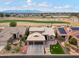 Aerial view of house with two-car garage, landscaping, and golf course view at 3182 N 159Th Dr, Goodyear, AZ 85395