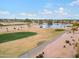 Aerial view of a golf course community with a pond and houses at 3182 N 159Th Dr, Goodyear, AZ 85395