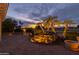 Evening view of backyard patio with water feature, seating, and golf course view at 3182 N 159Th Dr, Goodyear, AZ 85395