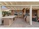 Outdoor kitchen with built-in grill and seating area at 3182 N 159Th Dr, Goodyear, AZ 85395