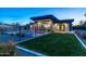 Well-maintained backyard featuring a modern home, lush green lawn, and sparkling swimming pool at 4414 E Vermont S Ave, Phoenix, AZ 85018