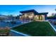 Well-maintained backyard featuring a modern home, lush green lawn, and sparkling swimming pool at 4414 E Vermont S Ave, Phoenix, AZ 85018