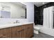 Elegant bathroom with a wood vanity, white countertop, and a black tile shower with a glass door at 4414 E Vermont S Ave, Phoenix, AZ 85018