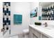 Modern bathroom featuring stylish blue and white tile accents, and a sleek vanity with a white countertop at 4414 E Vermont S Ave, Phoenix, AZ 85018