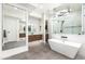 Modern bathroom with a floating vanity, large mirror, soaking tub, and a glass-enclosed walk-in shower at 4414 E Vermont S Ave, Phoenix, AZ 85018
