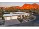 Modern home with a flat roof, desert landscaping, and a mountain backdrop at 4414 E Vermont S Ave, Phoenix, AZ 85018