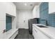 Modern laundry room with white cabinets, blue tile backsplash, and stainless steel washer and dryer at 4414 E Vermont S Ave, Phoenix, AZ 85018