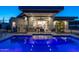 Tranquil pool reflects lights from the contemporary home, creating a serene backyard atmosphere at 4414 E Vermont S Ave, Phoenix, AZ 85018
