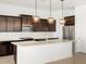 Close-up view of kitchen island featuring stainless steel appliances, granite countertops, and pendant lighting at 4828 N 177Th Ln, Goodyear, AZ 85395