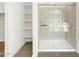 Glass enclosed tiled shower and open shelving for bathroom storage at 4828 N 177Th Ln, Goodyear, AZ 85395