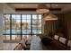 Dining area with long wooden table and modern pendant lights with a pool view at 5000 N Camelback Ridge Rd # 109, Scottsdale, AZ 85251