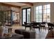 Staged living room with dining area, wood beams, large windows, and view of outdoor pool at 5000 N Camelback Ridge Rd # 109, Scottsdale, AZ 85251