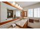 Bright bathroom with a large mirror, granite countertop, wood cabinets, and shuttered windows at 5306 N 20Th St, Phoenix, AZ 85016