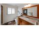 Well-lit bathroom featuring a granite countertop, wood cabinets, tiled floors, and shuttered windows at 5306 N 20Th St, Phoenix, AZ 85016