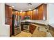 Cozy kitchen featuring stainless steel appliances, granite countertops, and dark wood cabinets at 5450 E Deer Valley Dr # 4015, Phoenix, AZ 85054