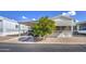 Single-wide manufactured home with carport, mature landscaping, and paved driveway at 7750 E Broadway Rd # 309, Mesa, AZ 85208