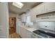 Galley kitchen with white cabinets, electric stove, and double sink at 7750 E Broadway Rd # 309, Mesa, AZ 85208