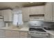 White kitchen cabinets, electric stove top, and double sink at 7750 E Broadway Rd # 309, Mesa, AZ 85208