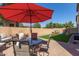 Outdoor patio furniture under a red umbrella in backyard with artificial turf at 8454 E Keats Ave, Mesa, AZ 85209