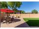 Relaxing backyard with patio furniture, artificial turf, and a red umbrella at 8454 E Keats Ave, Mesa, AZ 85209