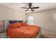 Spacious bedroom with orange bedding and ceiling fan at 8454 E Keats Ave, Mesa, AZ 85209