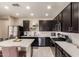 Modern kitchen with dark cabinetry, island, and stainless steel appliances at 8454 E Keats Ave, Mesa, AZ 85209