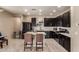 Modern kitchen with dark cabinetry, island, and stainless steel appliances at 8454 E Keats Ave, Mesa, AZ 85209