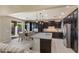 Modern kitchen with dark cabinetry, granite counters, and island at 9038 W Orchid Ln, Peoria, AZ 85345