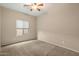 Bedroom features neutral carpet, a ceiling fan and a window letting in natural light at 9911 W Jessie Ln, Peoria, AZ 85383
