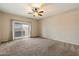 Spacious bedroom features plush carpet, a ceiling fan and a sliding glass door to the yard at 9911 W Jessie Ln, Peoria, AZ 85383