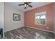 Bright bedroom with wood-look floors, ceiling fan, and accent wall at 9911 W Jessie Ln, Peoria, AZ 85383
