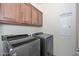 Laundry room with modern washer and dryer and ample cabinetry at 9911 W Jessie Ln, Peoria, AZ 85383