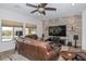 Living room with stone accent wall, large screen TV, and leather sofas at 9911 W Jessie Ln, Peoria, AZ 85383