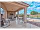 Covered patio with seating area, stone wall, and TV at 9911 W Jessie Ln, Peoria, AZ 85383