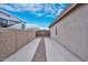 Long side yard with concrete, gravel, and wooden gate at 9911 W Jessie Ln, Peoria, AZ 85383