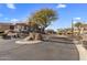 Gated entrance to community with paved road and desert landscaping at 10222 E Southwind Ln # 1066, Scottsdale, AZ 85262