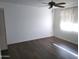 Bright bedroom with dark laminate wood flooring and a window at 11001 W Connecticut Ave, Sun City, AZ 85351