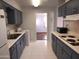 Galley style kitchen with gray cabinets and white countertops at 11001 W Connecticut Ave, Sun City, AZ 85351